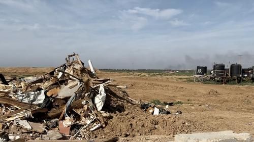 Вид с израильской военной базы. Над Газой стоит черный дым. На переднем плане — остатки домов, сожженных ХАМАС.
